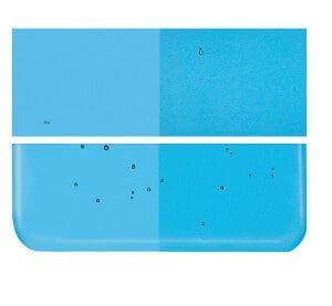 A picture of a 1116-0030 Turquoise Blue Transparent tile with a black spot in the middle.