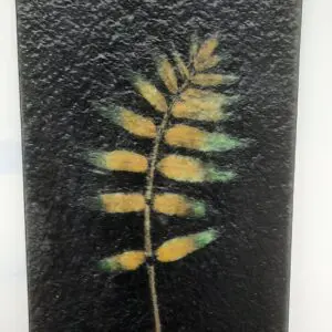 A Vitra Fossil Panel Class plate with a yellow leaf on it.