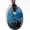 Blue and black patterned pendant on cord.