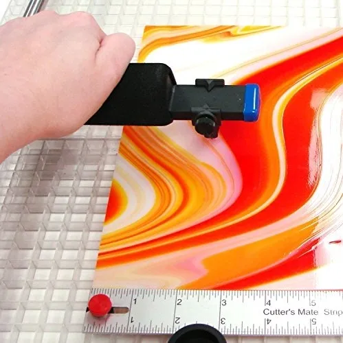 Hand using a cutter on colorful sheet.