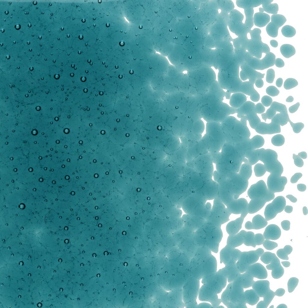 Blue liquid with scattered bubbles and droplets.